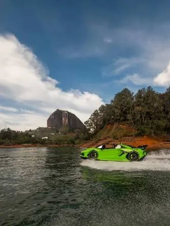 A sporty jet car sailing in front of El Peñón de Guatapé.