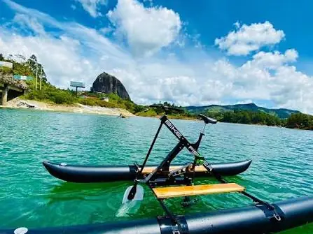 Una bicicleta náutica sobre el embalse, con el Peñón al fondo.