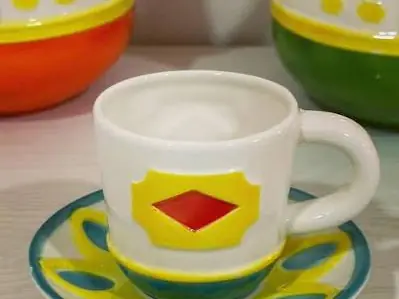 Una taza de cerámica pintada con un zócalo de rombos.