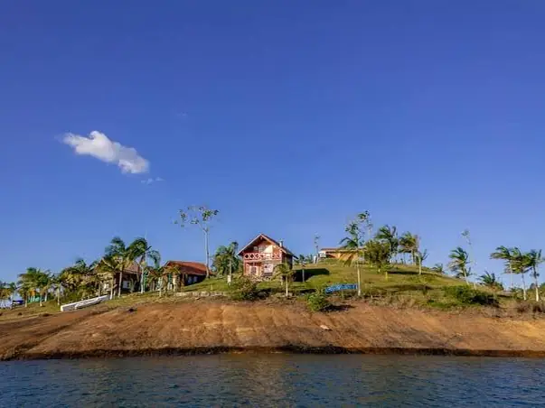 La Isla de la Fantasía sobre el embalse, con sus construcciones entre árboles.