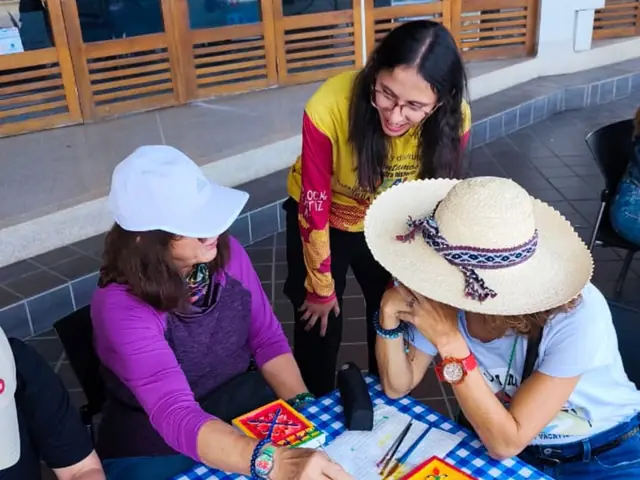 Visitantes pintando su propio zócalo en una mesa de taller.