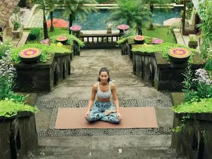 Una persona meditando en un jardín con estanques.