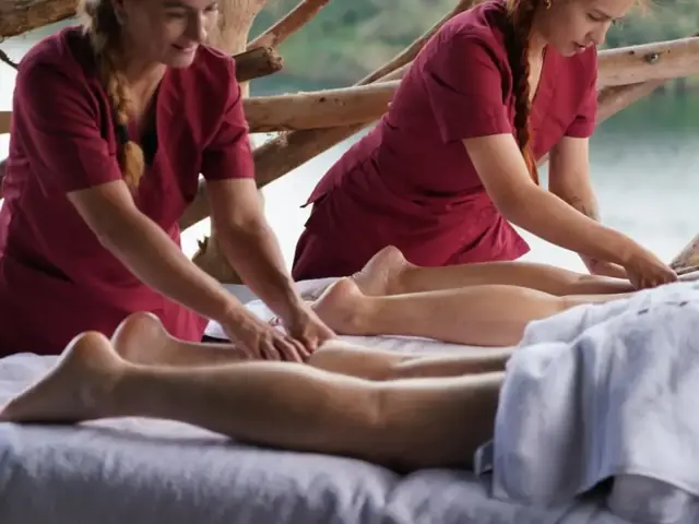 Dos terapeutas dando un masaje en una sala de spa.