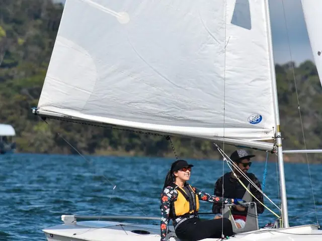 Un velero ligero con dos tripulantes navegando por el embalse.