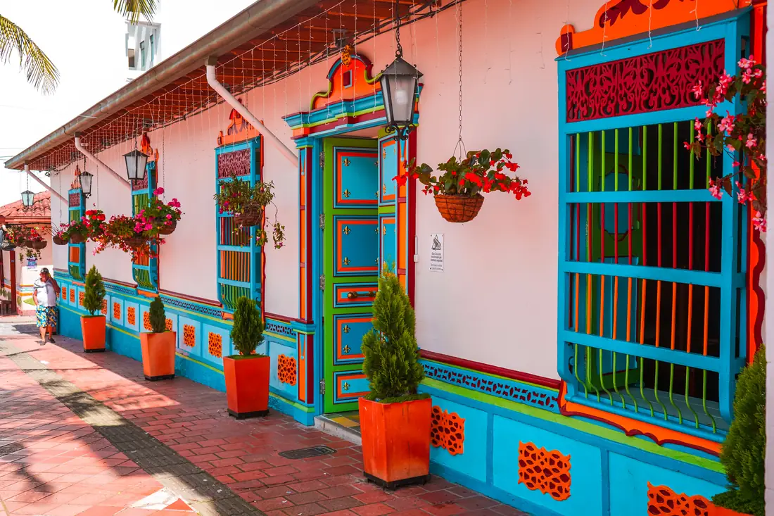 Façade of the Casa Cural, white with colourful doors, windows and zócalos.