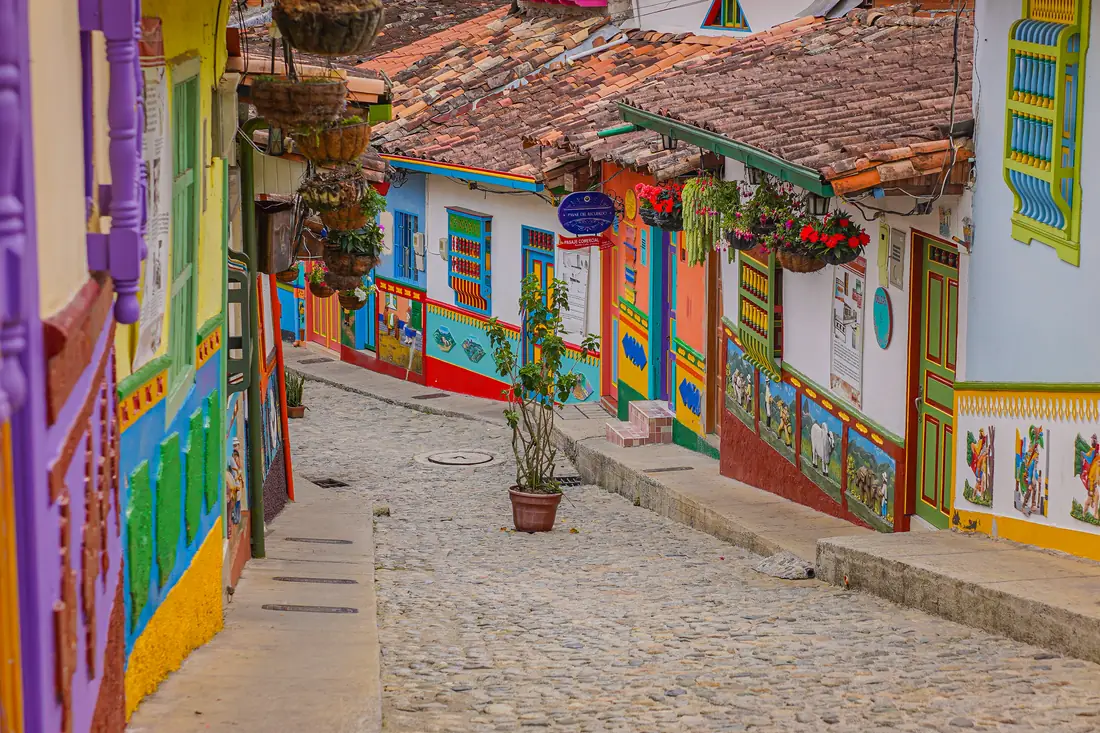 Calle del Recuerdo, cobbled, with zócalos and flowerpots on the façades.