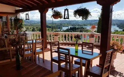 Restaurant tables on a terrace overlooking the Guatapé reservoir.