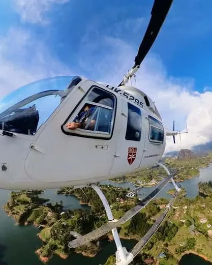 Un helicóptero sobrevolando el embalse de Guatapé, con las islas y el Peñón al fondo.