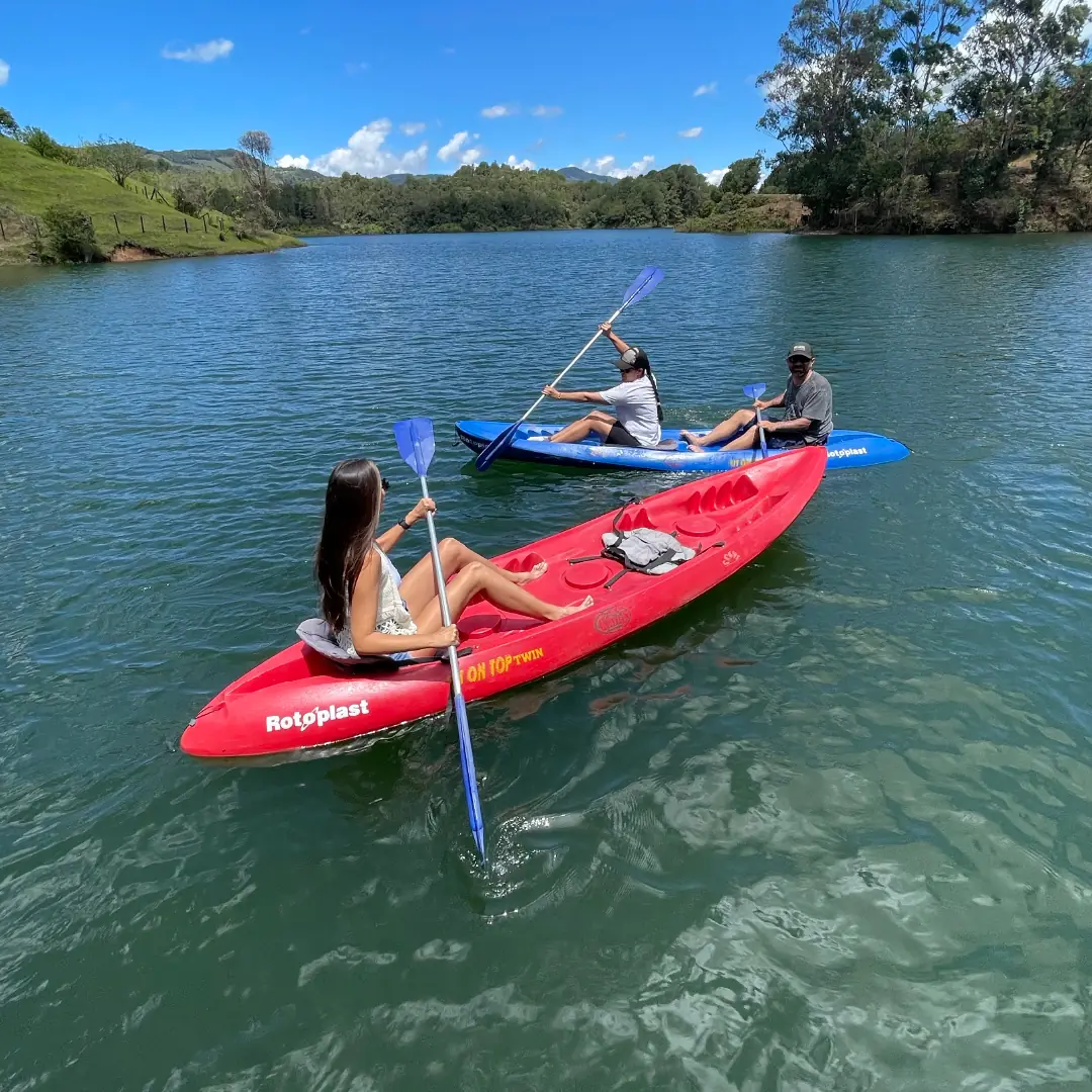 Kayaks de colores sobre el agua quieta del embalse.
